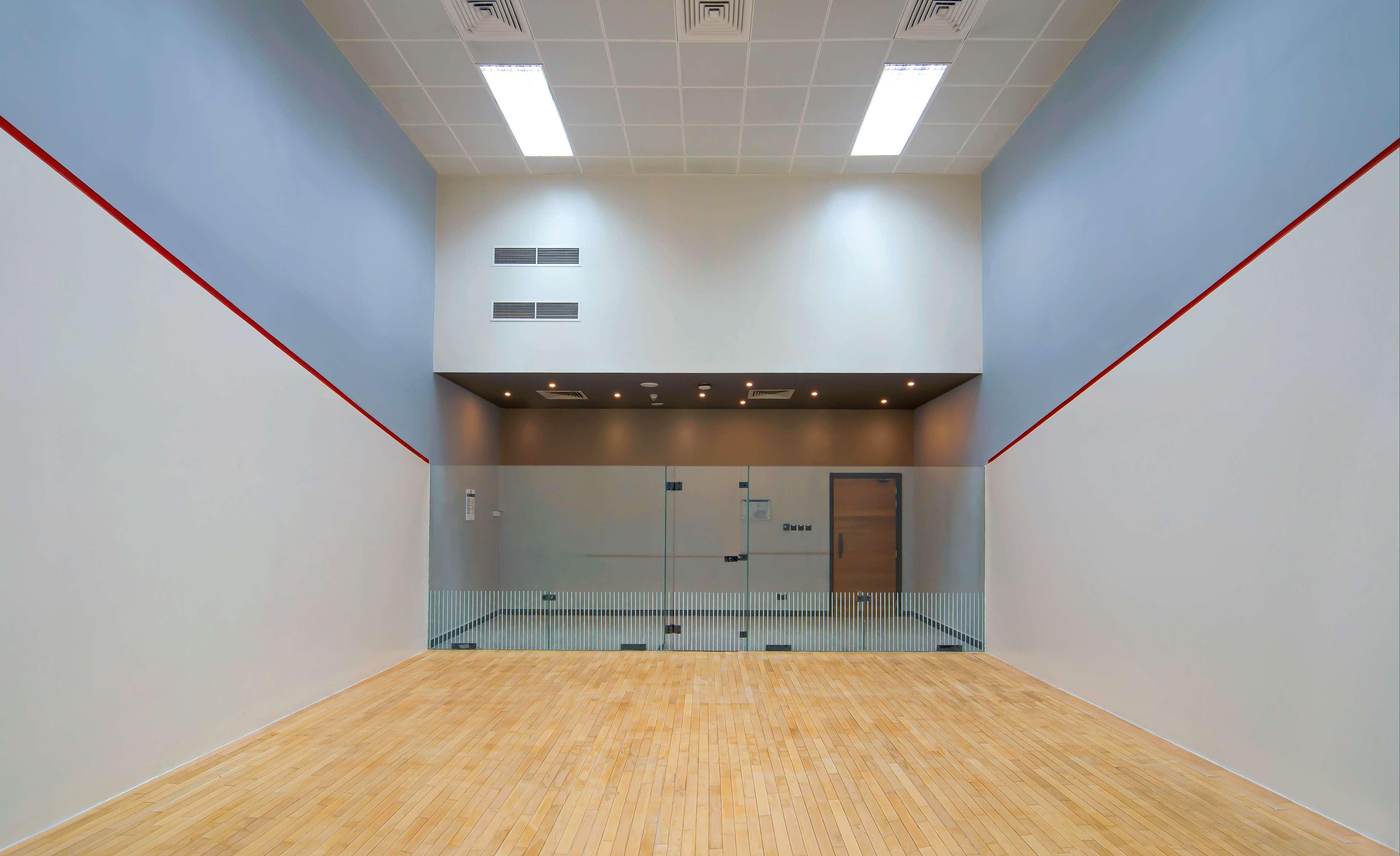 Radisson Blu Hotel & Resort, Abu Dhabi Corniche Esterno foto The image shows an indoor squash court. The court has a wooden floor and four walls, two of which are painted white with a red line running horizontally at the height appropriate for the game. One wall features large glass panels, likely for viewing,